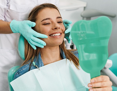 patient smiling in dental mirror